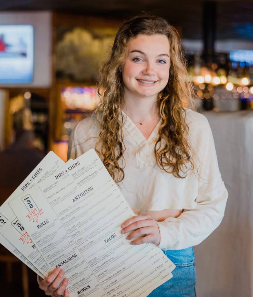 A Tower7 waitress holding menus.