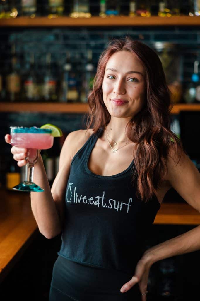 A Tower7 bartender holding a pink margarita.
